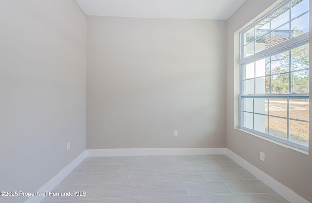 unfurnished room with baseboards