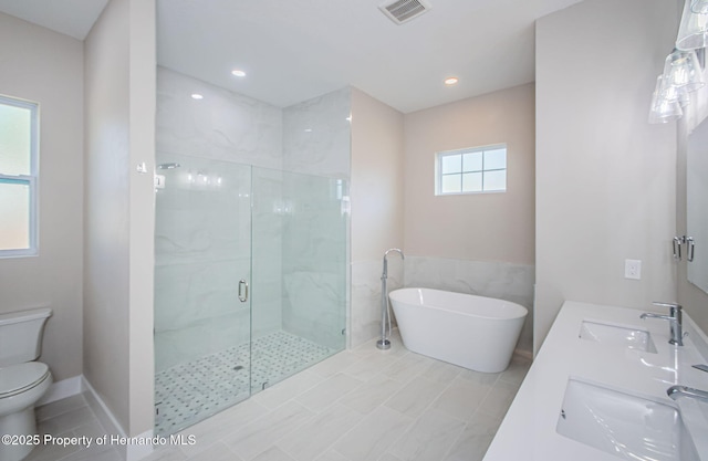 bathroom featuring toilet, a marble finish shower, visible vents, and a sink