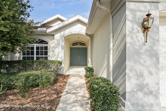 view of exterior entry with stucco siding