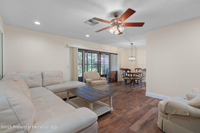 living area with dark wood-style flooring, recessed lighting, visible vents, and a ceiling fan