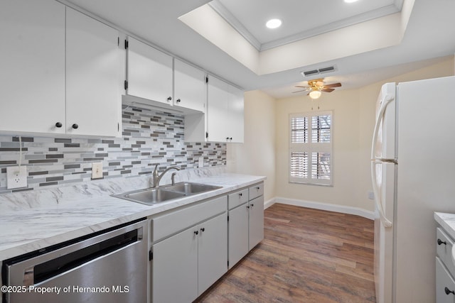 kitchen with tasteful backsplash, visible vents, freestanding refrigerator, a sink, and dishwasher