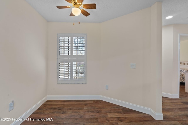 spare room featuring ceiling fan, a textured ceiling, baseboards, and wood finished floors