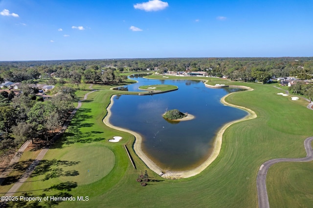 drone / aerial view featuring golf course view, a water view, and a wooded view