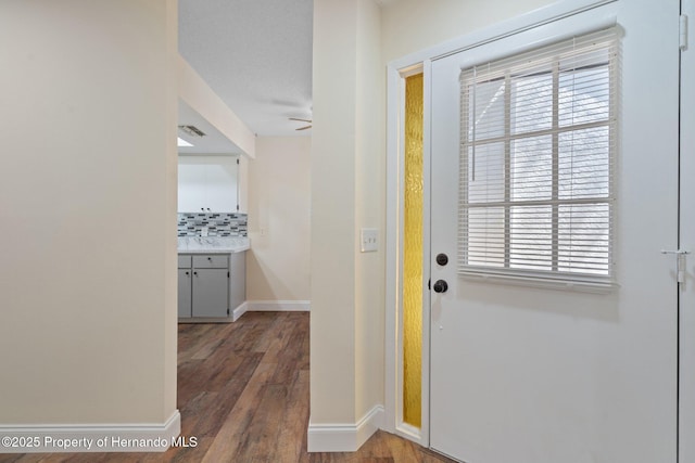 doorway featuring visible vents, baseboards, and wood finished floors