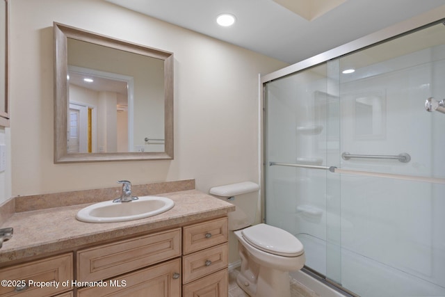 bathroom with recessed lighting, a shower stall, toilet, and vanity