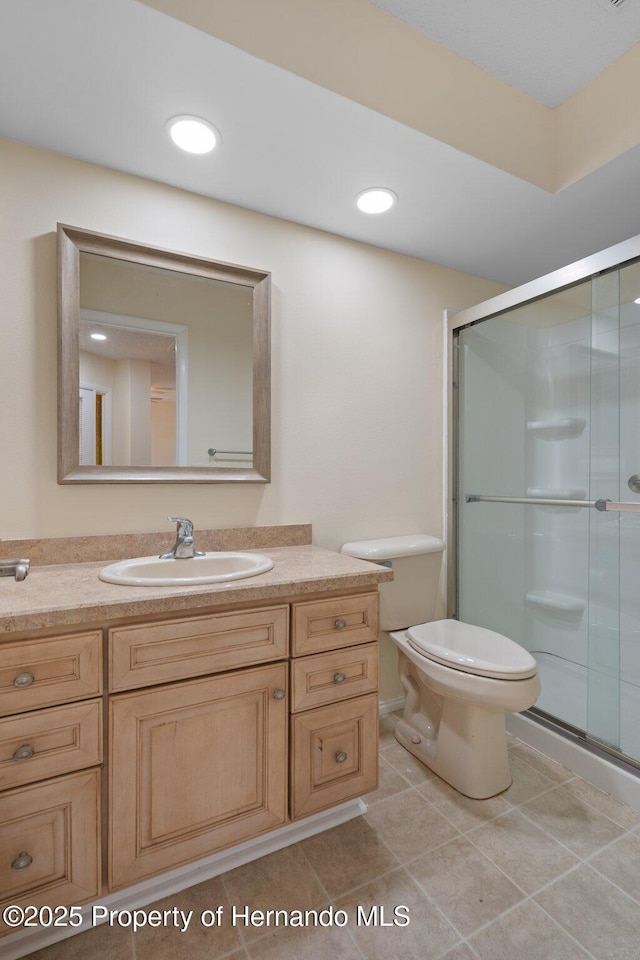 bathroom featuring tile patterned flooring, toilet, recessed lighting, vanity, and a stall shower