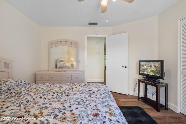 bedroom featuring visible vents, dark wood-type flooring, a ceiling fan, a textured ceiling, and baseboards