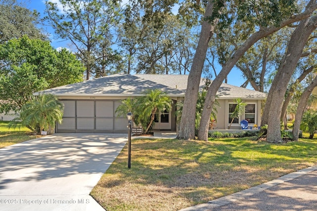 view of front facade featuring a garage, a front yard, and driveway