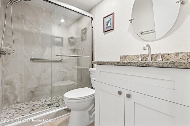 bathroom featuring a stall shower, vanity, and toilet