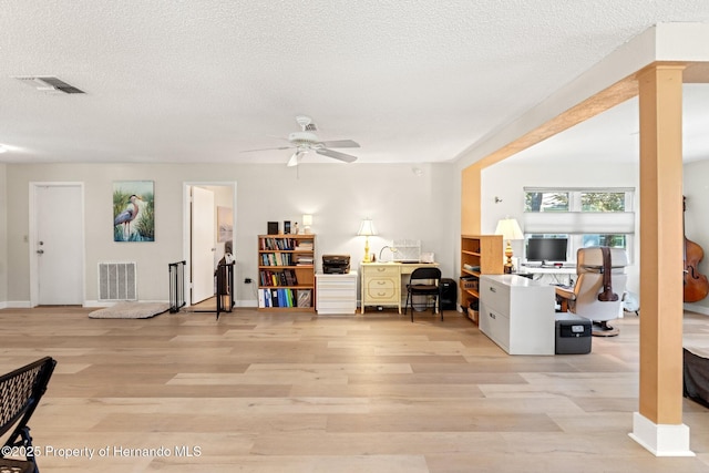 interior space with a textured ceiling, visible vents, and light wood-style floors