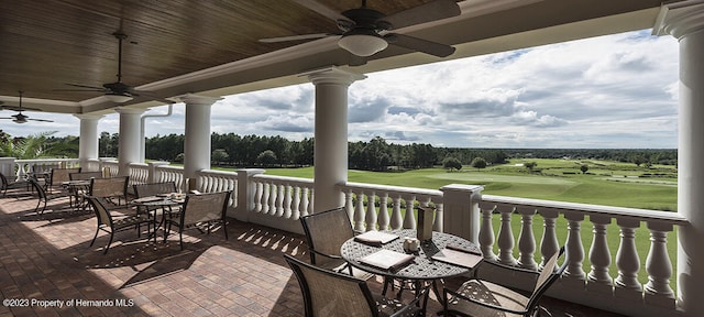 wooden deck featuring ceiling fan, outdoor dining space, and golf course view