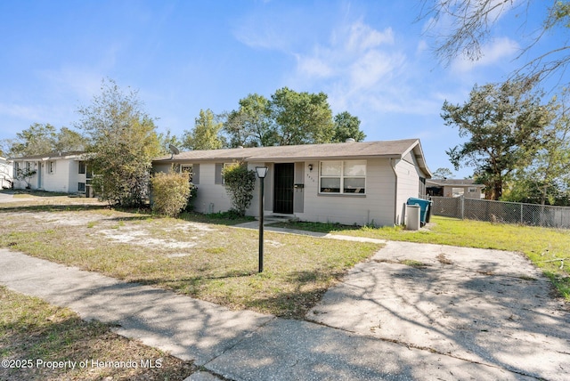 ranch-style house with a front yard and fence