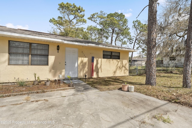 view of front facade featuring fence and stucco siding