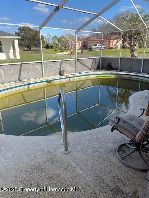 outdoor pool with a lanai and a patio area