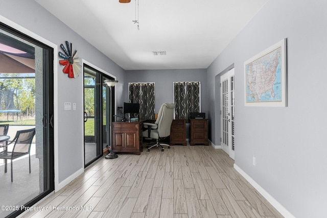 13415 Ester Dr, Brooksville, FL 34613 - home office with light wood-style flooring, visible vents, baseboards, and french doors
