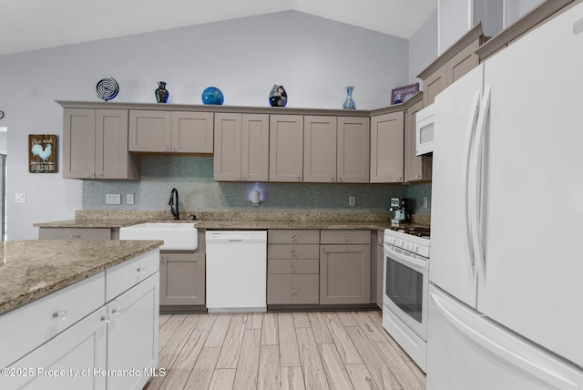 13415 Ester Dr, Brooksville, FL 34613 - kitchen with lofted ceiling, gray cabinets, a sink, and white appliances