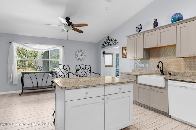 13415 Ester Dr, Brooksville, FL 34613 - kitchen with vaulted ceiling, tasteful backsplash, white dishwasher, a sink, and ceiling fan