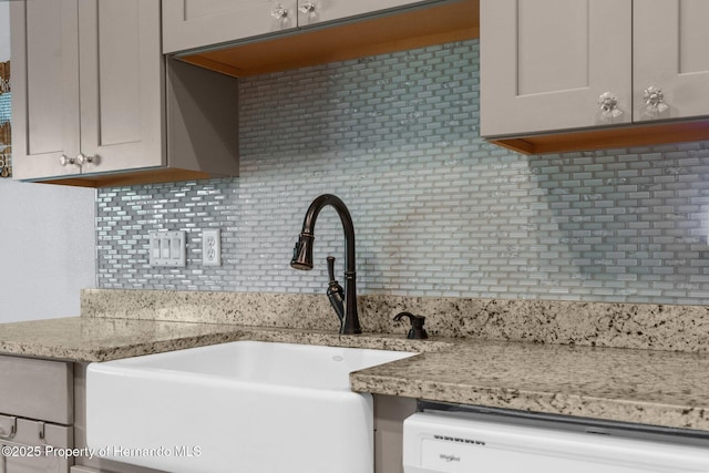 13415 Ester Dr, Brooksville, FL 34613 - kitchen featuring dishwashing machine, a sink, light stone counters, and tasteful backsplash