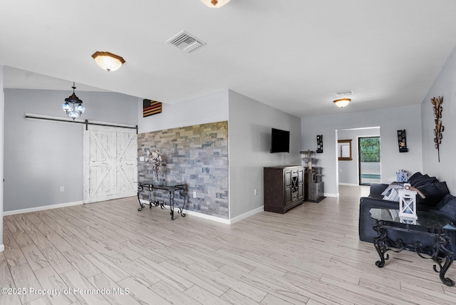 13415 Ester Dr, Brooksville, FL 34613 - living room with wood finished floors, visible vents, and a barn door