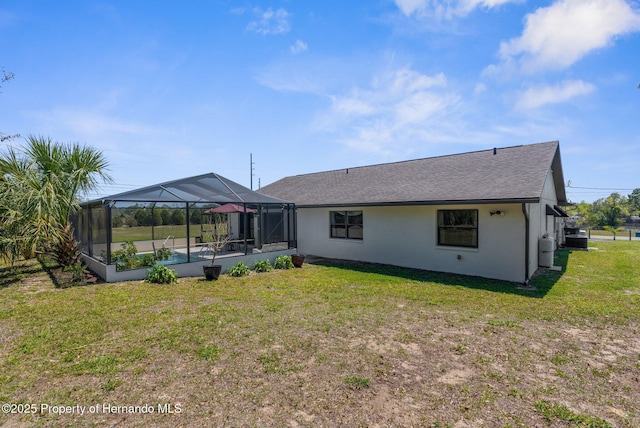 13415 Ester Dr, Brooksville, FL 34613 - back of house featuring roof with shingles, central AC unit, a lanai, a lawn, and stucco siding