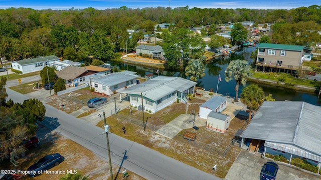 aerial view with a residential view, a water view, and a wooded view