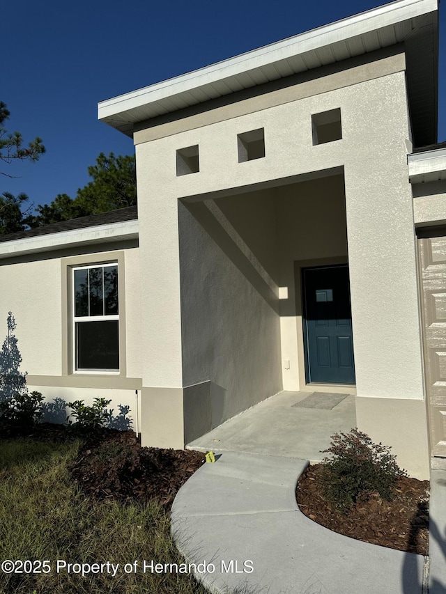 property entrance with stucco siding