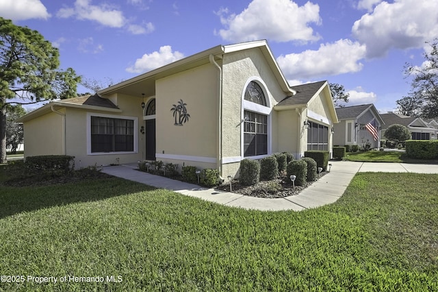 view of side of home with a garage, a yard, concrete driveway, and stucco siding