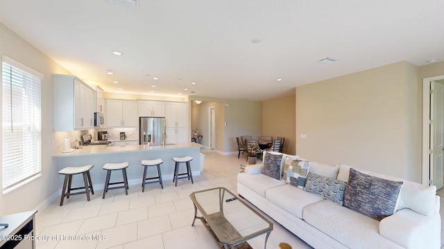 living room featuring recessed lighting, visible vents, baseboards, and light tile patterned floors