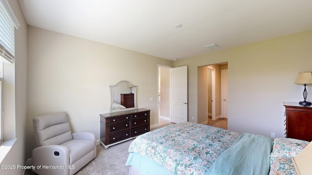 bedroom featuring light colored carpet, visible vents, and baseboards