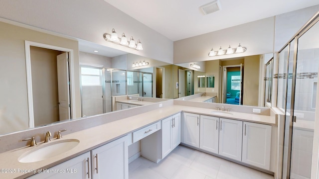 full bathroom with double vanity, a sink, visible vents, and a shower stall