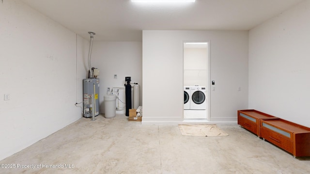 interior space with water heater and washer and clothes dryer