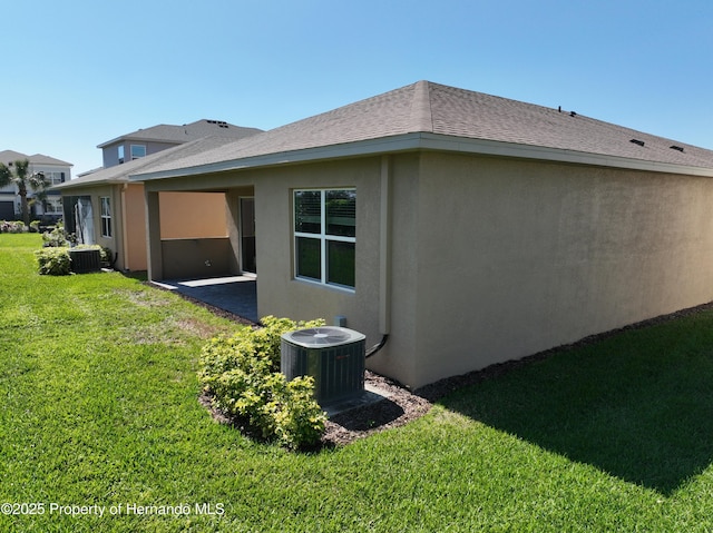 view of home's exterior featuring a patio area, central AC, a lawn, and stucco siding