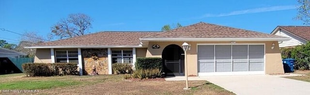 ranch-style house with a garage, driveway, and stucco siding