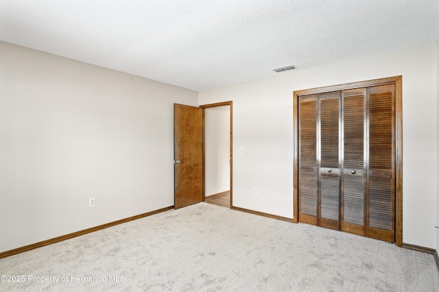 2013 Meredith Dr, Spring Hill, FL 34608 - unfurnished bedroom with carpet, a closet, baseboards, and a textured ceiling