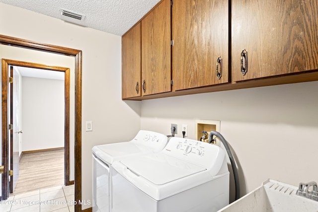 2013 Meredith Dr, Spring Hill, FL 34608 - washroom with cabinet space, washer and dryer, light tile patterned floors, a textured ceiling, and baseboards
