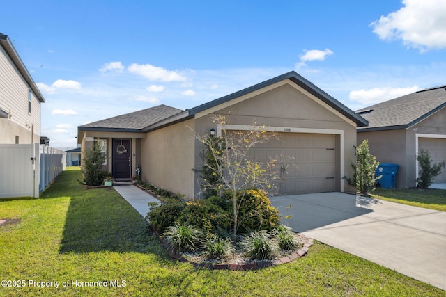 view of front facade featuring a garage, fence, driveway, stucco siding, and a front yard