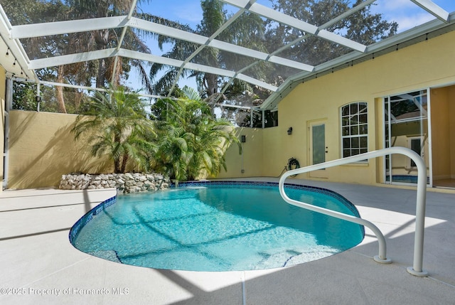 pool with glass enclosure and a patio