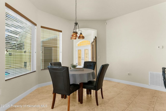 dining room with arched walkways, french doors, visible vents, and baseboards