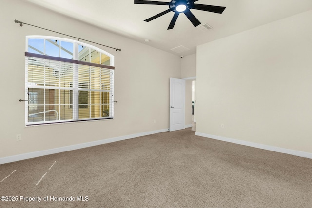 carpeted empty room with visible vents, baseboards, and a ceiling fan