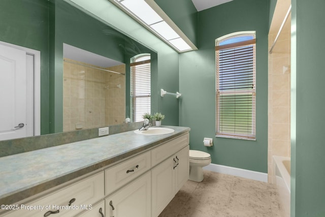 bathroom featuring a skylight, baseboards, toilet, tile patterned flooring, and vanity