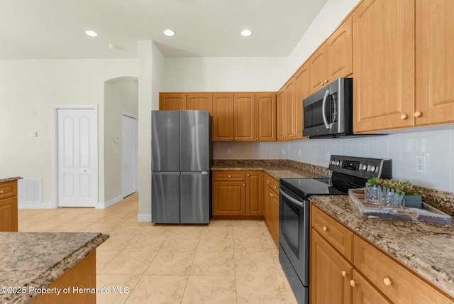 kitchen with stone counters, light tile patterned floors, stainless steel appliances, tasteful backsplash, and visible vents