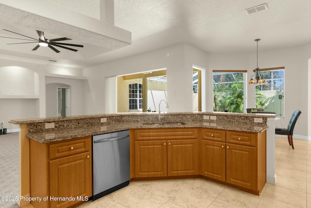 kitchen with visible vents, brown cabinetry, dishwasher, stone counters, and a sink