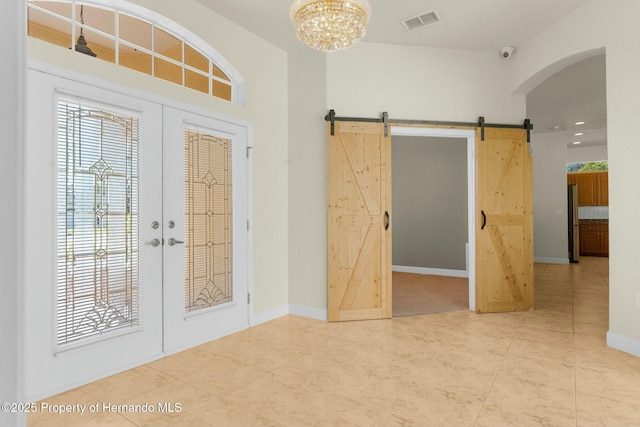 foyer entrance featuring a chandelier, french doors, a barn door, and visible vents