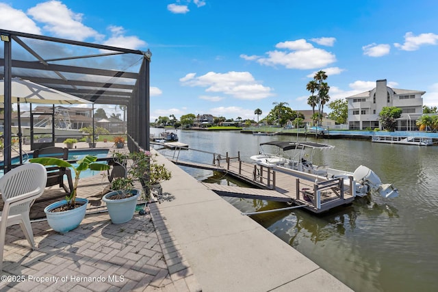 view of dock with glass enclosure, an outdoor pool, and a water view