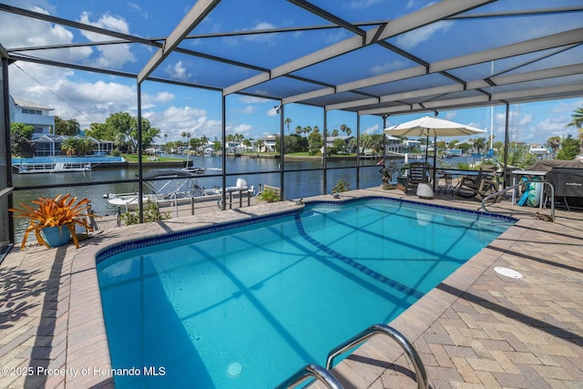 pool featuring a lanai, a patio area, and a water view