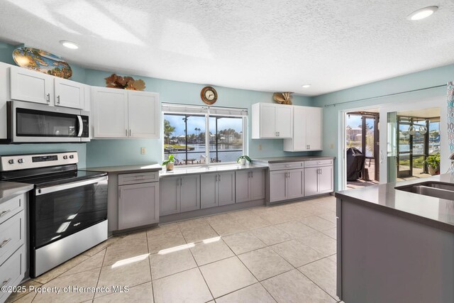 kitchen featuring appliances with stainless steel finishes, a healthy amount of sunlight, and light tile patterned floors