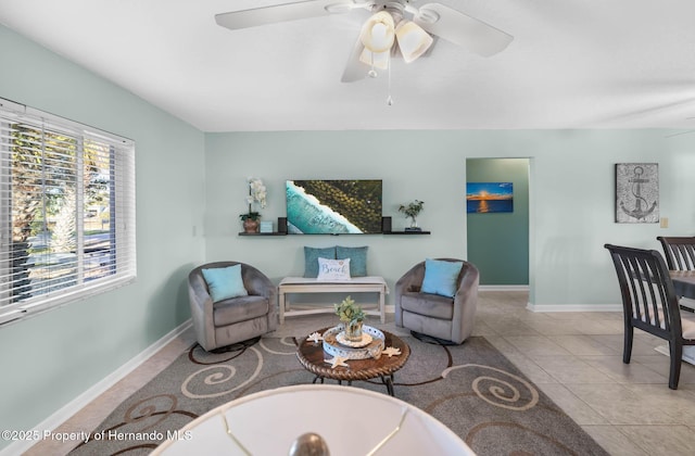 sitting room with baseboards, a ceiling fan, and tile patterned floors