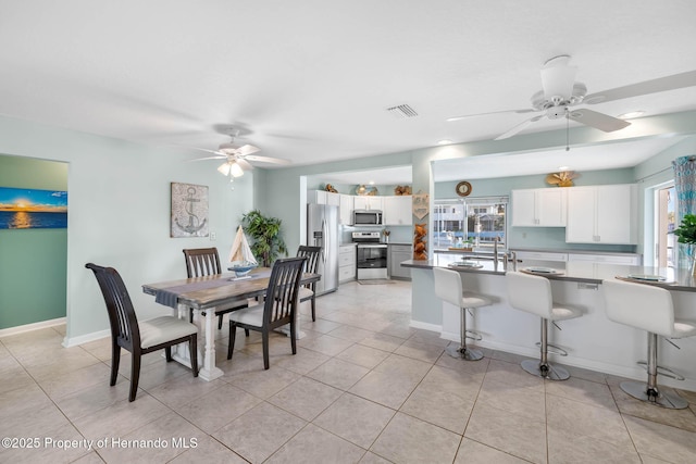 dining room featuring light tile patterned flooring, visible vents, and a ceiling fan