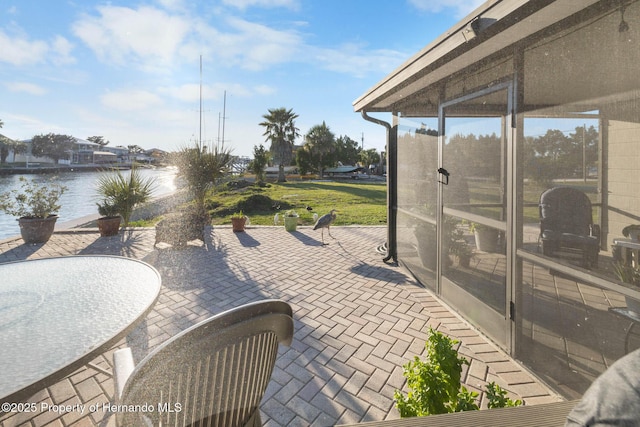 view of patio with a water view and a sunroom