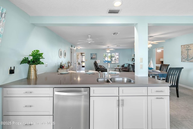 kitchen with open floor plan, a sink, visible vents, and white cabinetry